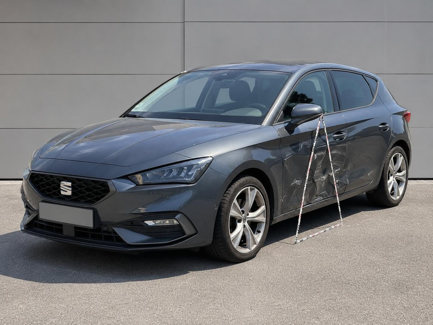 Seitenschaden an grauem SEAT Leon FR nach Haftpflichtunfall, vor Ort mit Maßband dokumentiert